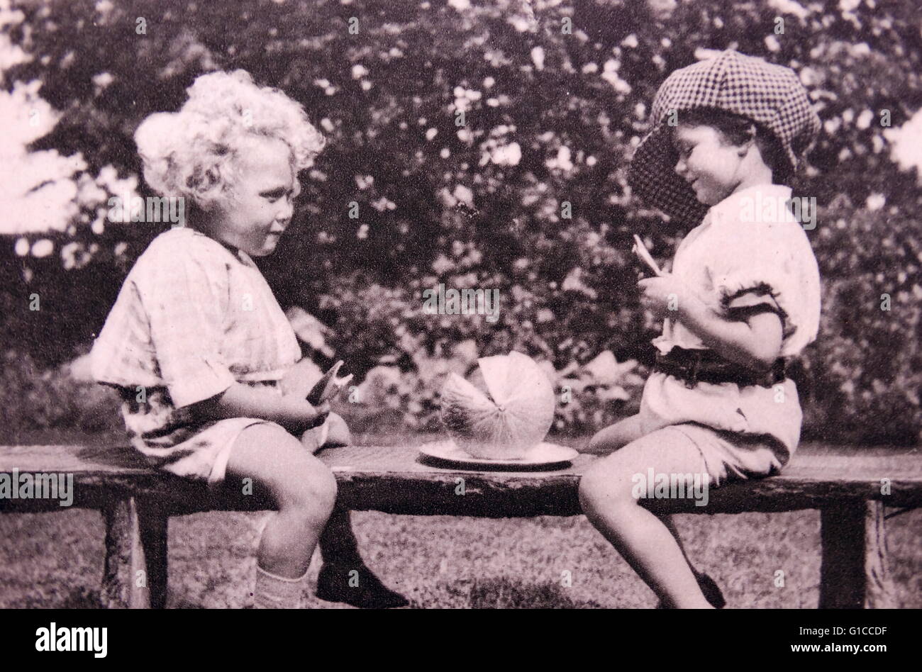 Vintage Foto von zwei Kindern auf einer Bank mit einer Wassermelone 1925 Stockfoto
