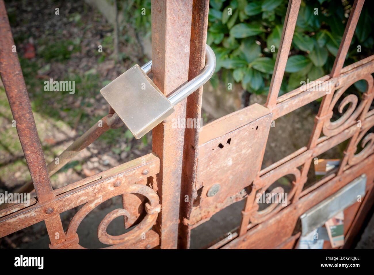 Rostiges Metall Tor geschlossen mit Vorhängeschloss - Konzept Bild Stockfoto