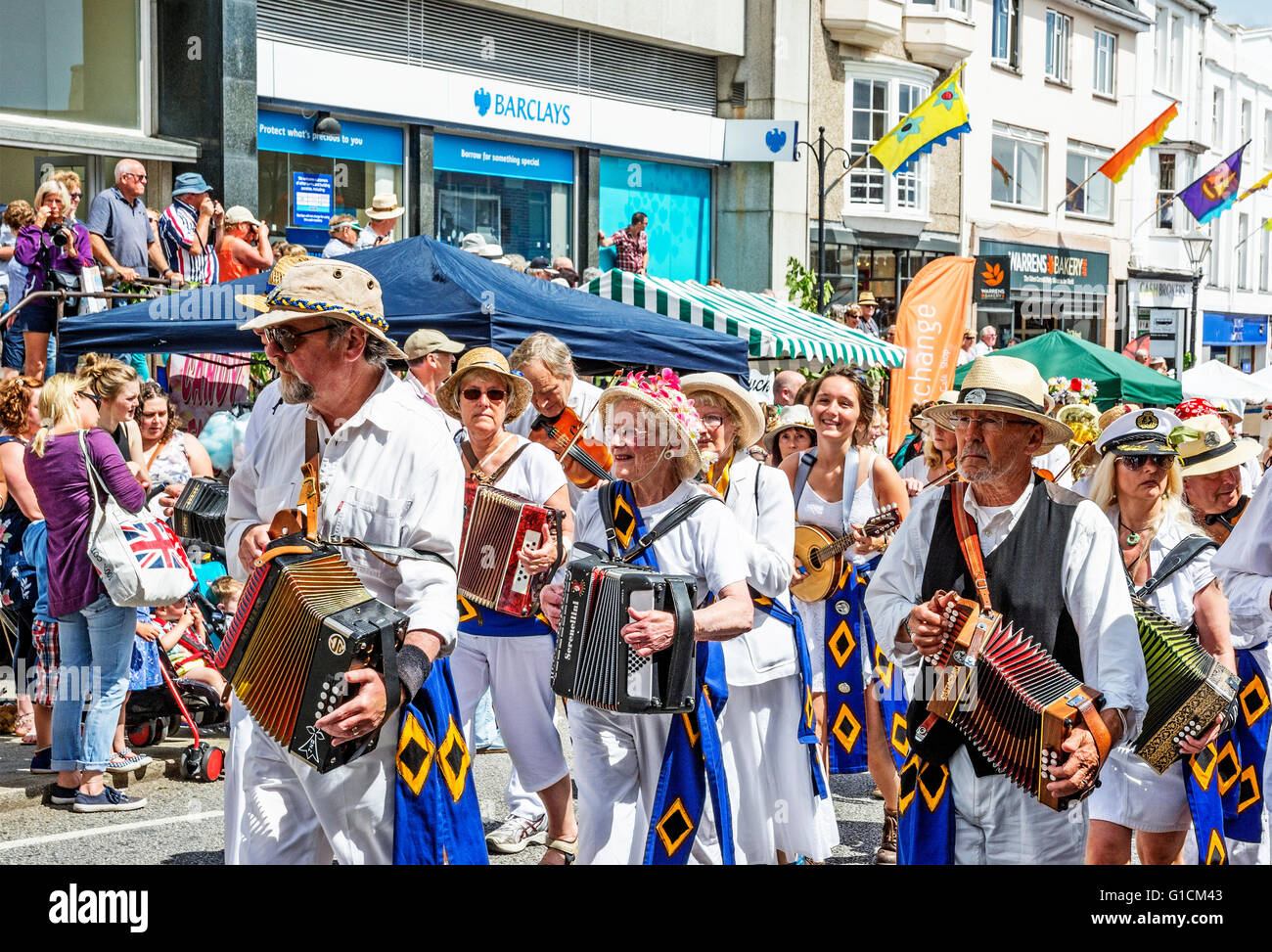Familien, Schulen und Freunde marschieren durch die Straßen von Penzance in Cornwall am Mazey Tag Teil des Golowan festival Stockfoto
