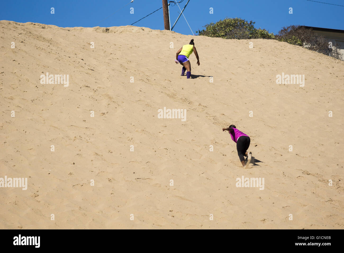 Manhattan Beach, Kalifornien USA - 10. Oktober 2015: Zwei Frauen Klettern Sanddüne im Rahmen des Fitness-Programm auf hot California Stockfoto