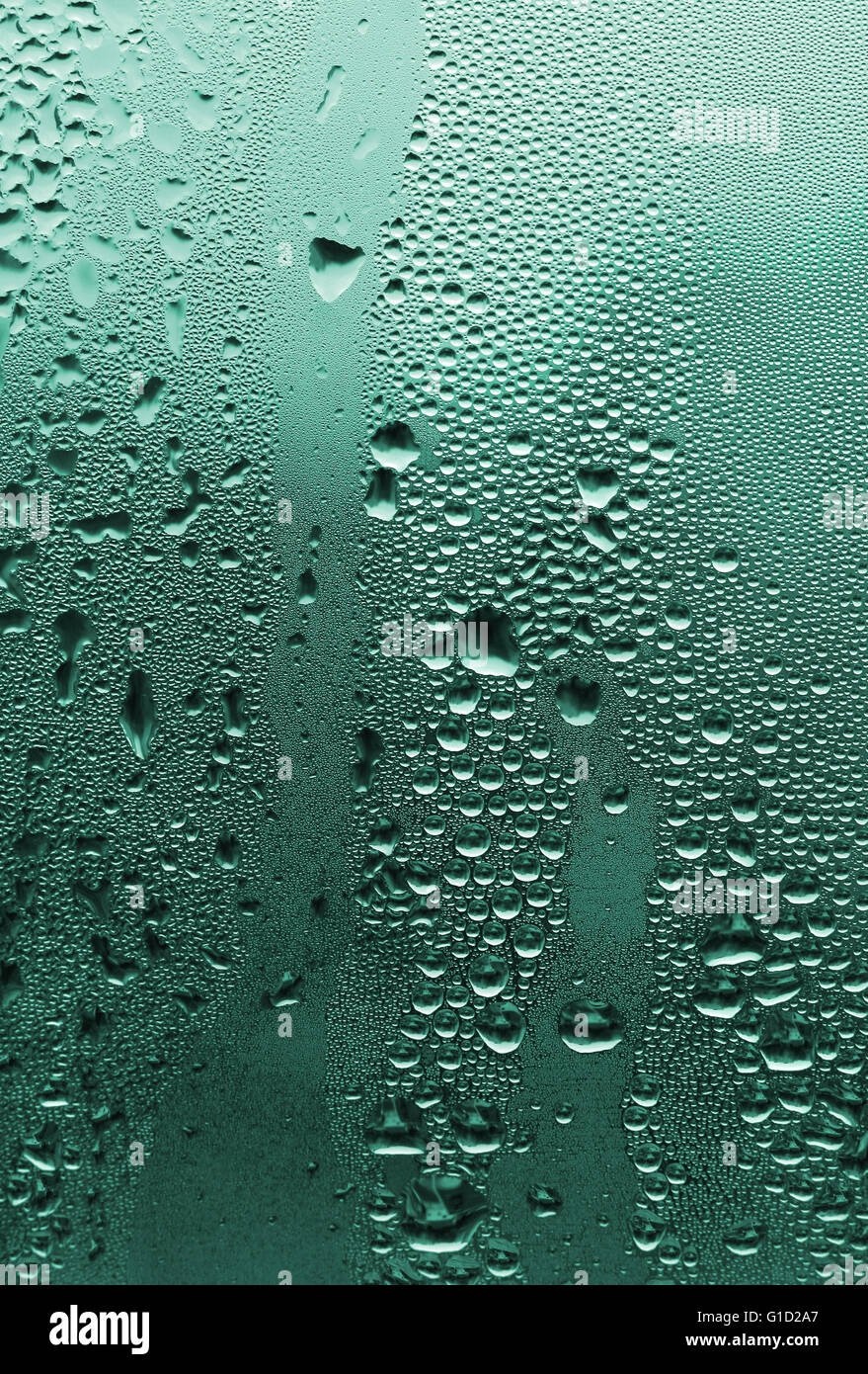 natürliche Wassertropfen große und feine auf grünem Glas Stockfoto