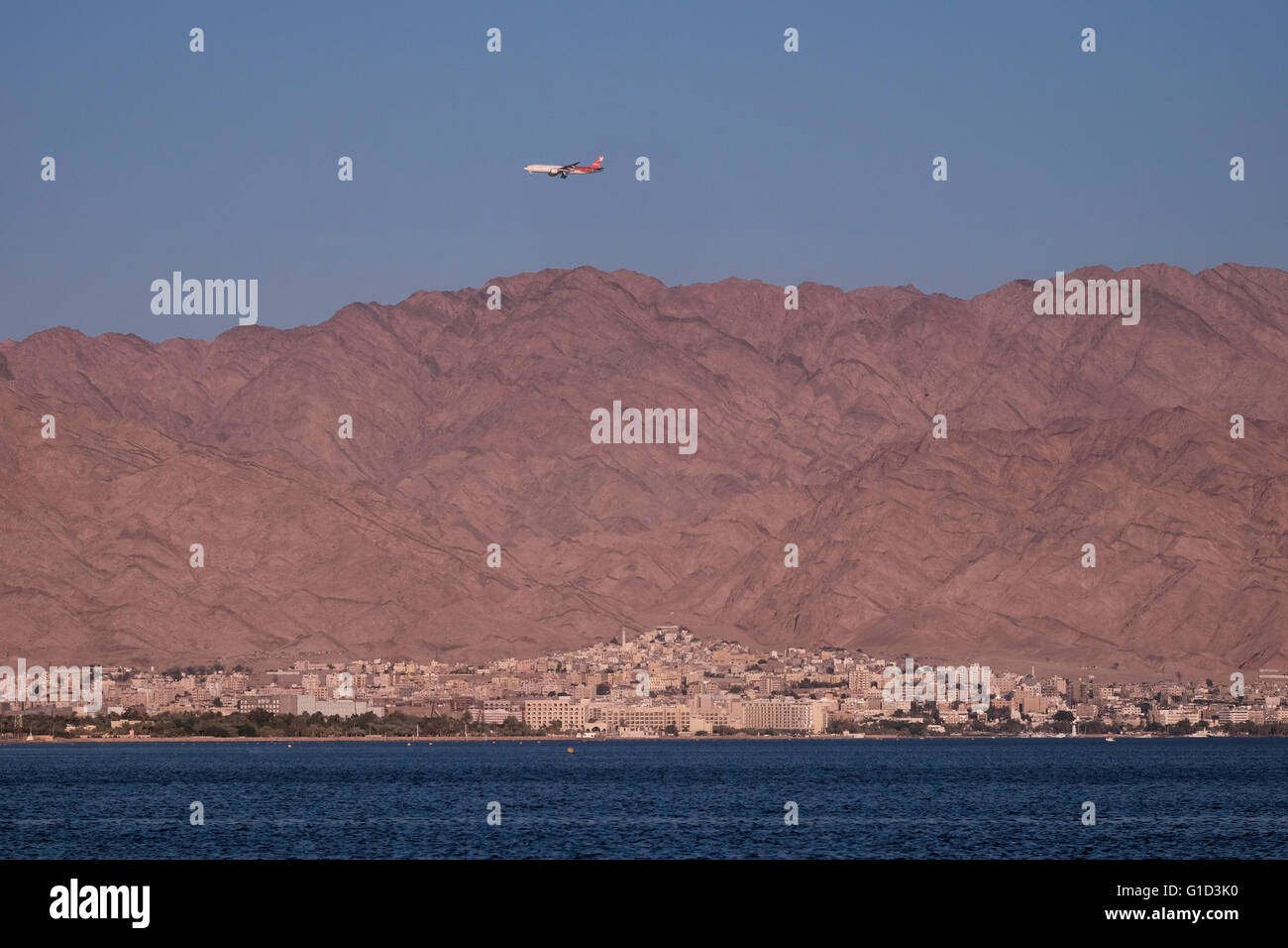 Ein Flugzeug der Nordwind Airlines eine russische Fluggesellschaft fliegt über die Stadt Aqaba die einzige Küstenstadt in Jordanien an der Nordspitze des Roten Meeres am Golf von Aqaba Stockfoto