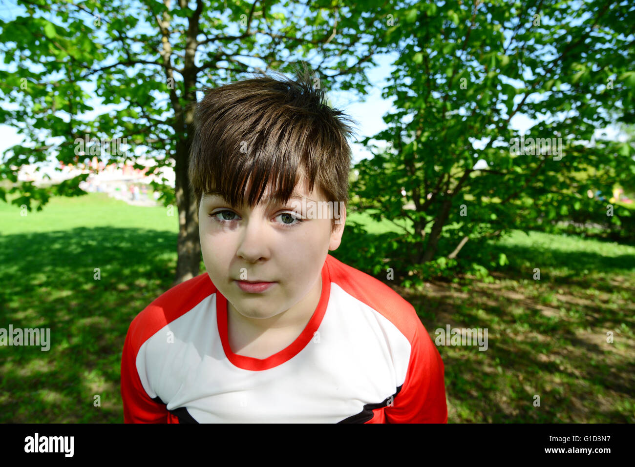 lustige Teenager Junge schaut in Kamera im Sommerpark Stockfoto