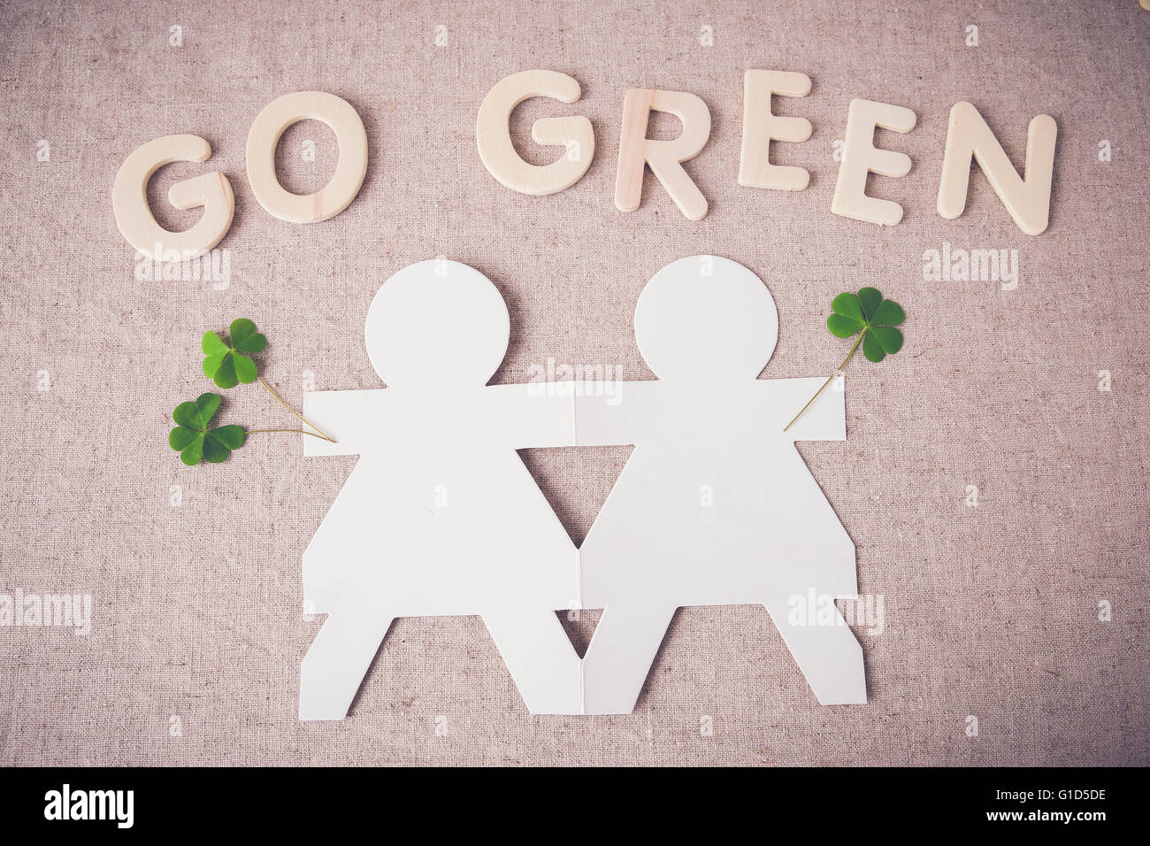 Hand in Hand mit grünen Blättern und "Grüne gehen" Wort Papierpuppen Stockfoto