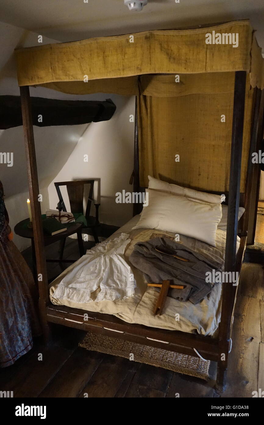Bett mit Wolljacke in Anne Hathaways Hütte, Anne Hathaway, die Ehefrau von William Shakespeare, als Kind lebte. -Upon-Avon, England. Der älteste Teil des Hauses wurde vor dem 15. Jahrhundert errichtet; das obere Teil ist 17. Jahrhundert Stockfoto
