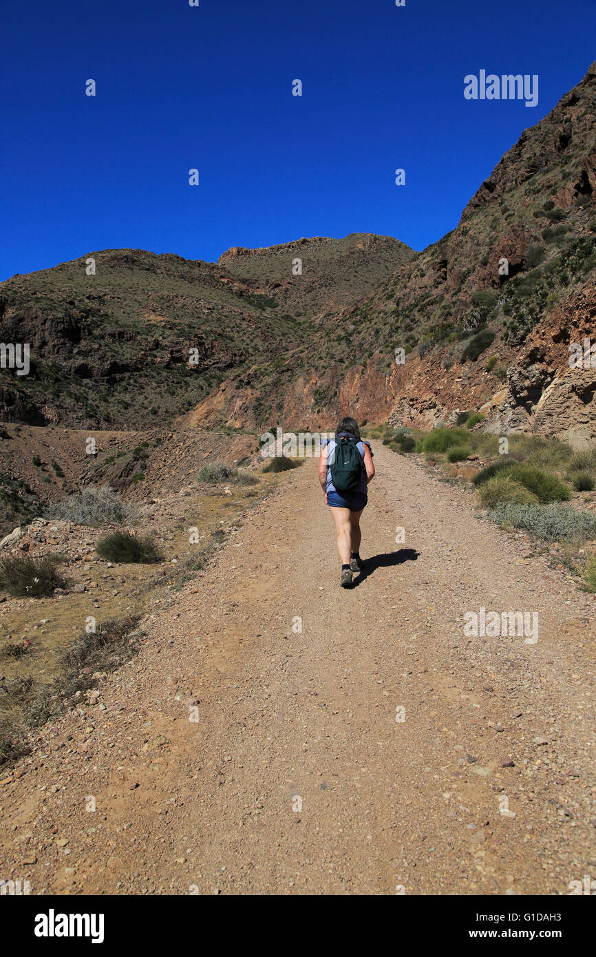 Frau zu Fuß entlang der Küstenweg in Cabo de Gata Nationalpark, in der Nähe von San José, Almeria, Spanien Stockfoto