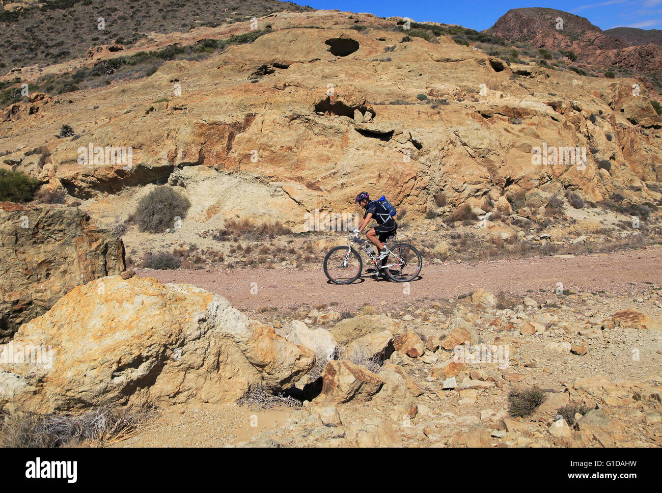 Person Radfahren im Nationalpark Cabo de Gata, Mónsul, in der Nähe von San José, Almeria, Spanien Stockfoto