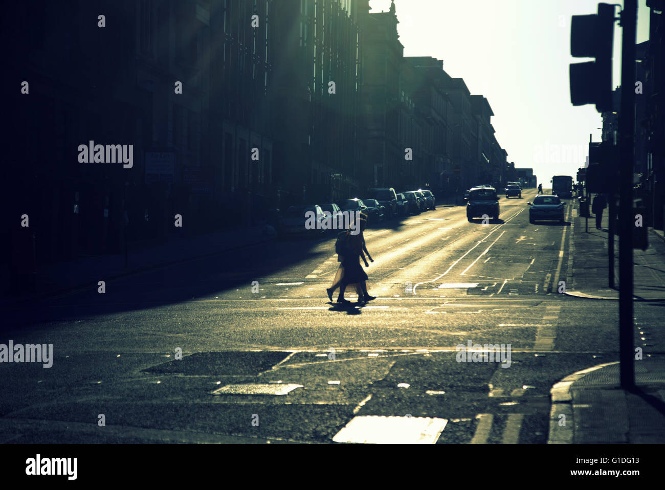 Silhouette von zwei Menschen auf Glasgow Straße mit Straße Contre-Jour Hintergrundbeleuchtung in Glasgow, Schottland, Großbritannien. Stockfoto