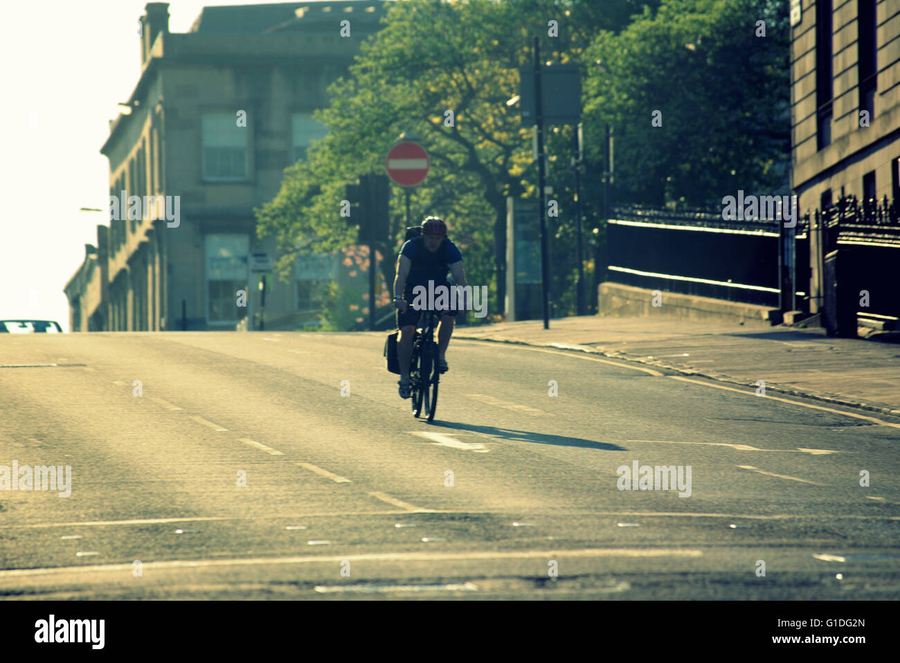 Silhouette eines Radfahrers auf Glasgow Straße mit Straße Cont-Jour Hintergrundbeleuchtung in Glasgow, Schottland, Großbritannien. Stockfoto