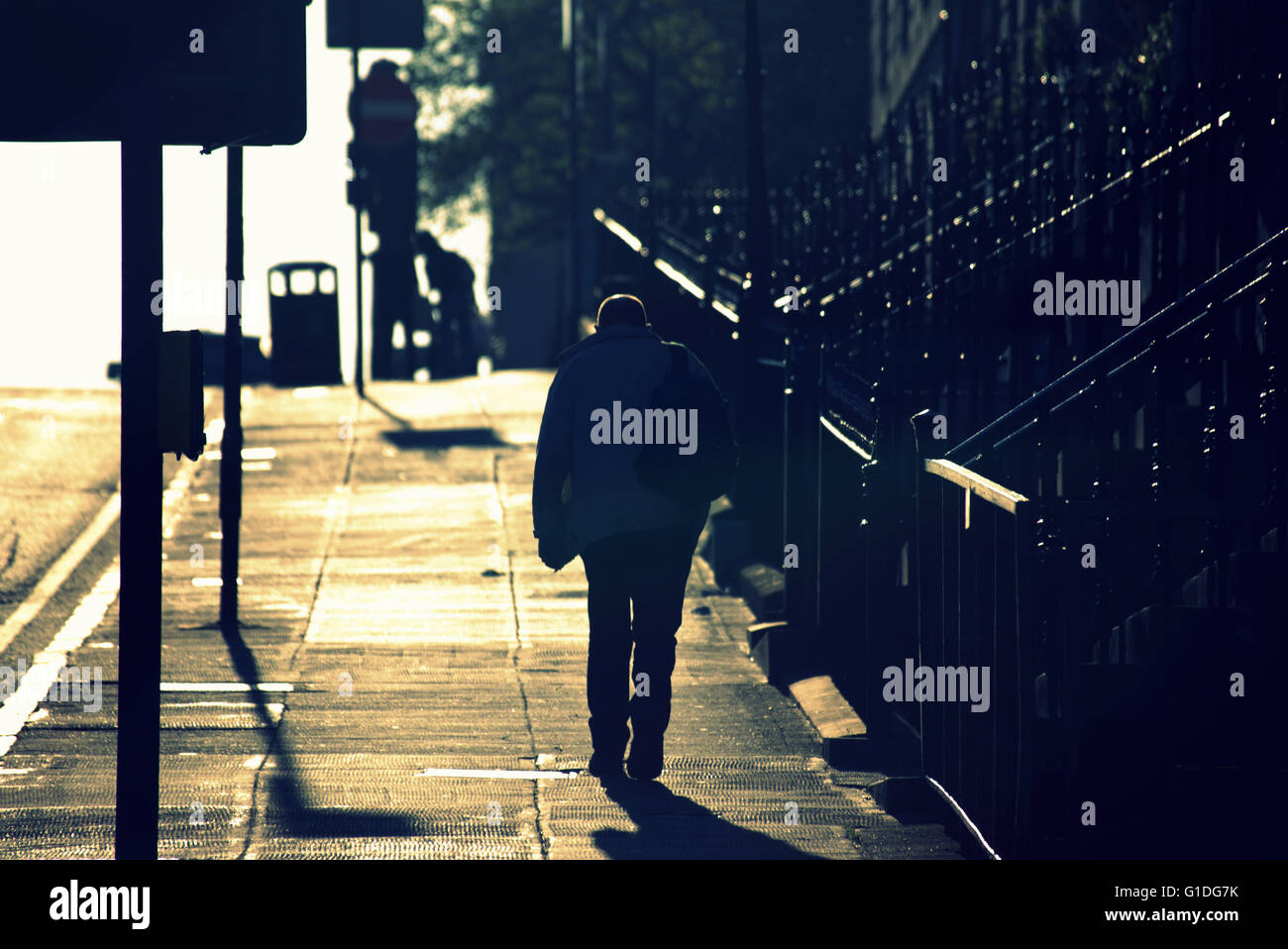 Silhouette eines Mannes auf Glasgow Straße mit Straße Contre-Jour hinterleuchtete in Glasgow, Schottland, Großbritannien. Stockfoto