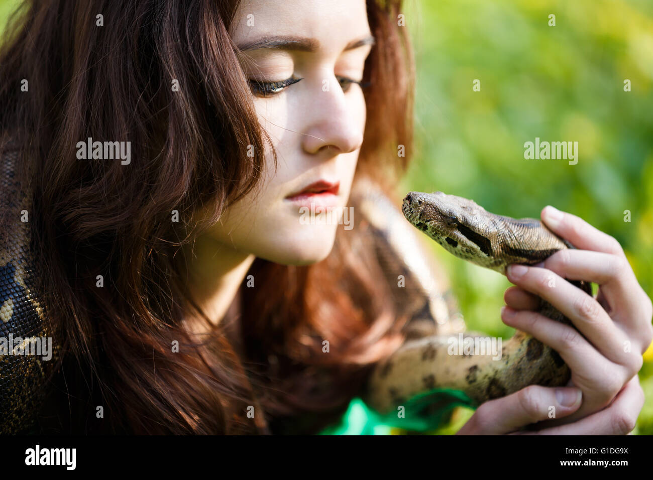 Attraktive Teenager-Mädchen halten die Python in der Nähe in der Nähe des Gesichts Stockfoto