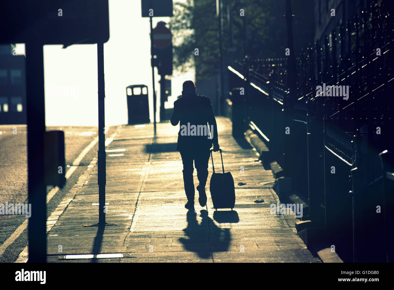 Silhouette der Mann am Telefon mobile auf Glasgow Straße mit Straße Contre-Jour Hintergrundbeleuchtung in Glasgow, Schottland, Großbritannien. Stockfoto