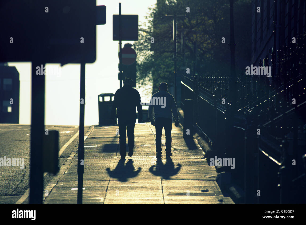 Silhouette von zwei Männern in Glasgow Straße mit Straße Contre-Jour hinterleuchtete in Glasgow, Schottland, Großbritannien. Stockfoto