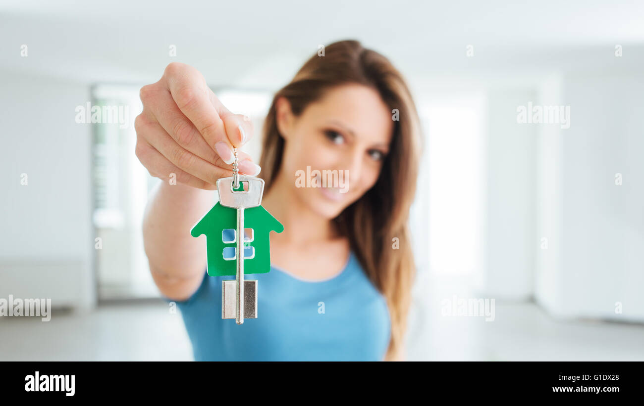 Schönen lächelnden Frau mit Hausschlüssel ihr neues Haus, Immobilien und Relocation-Konzept Stockfoto