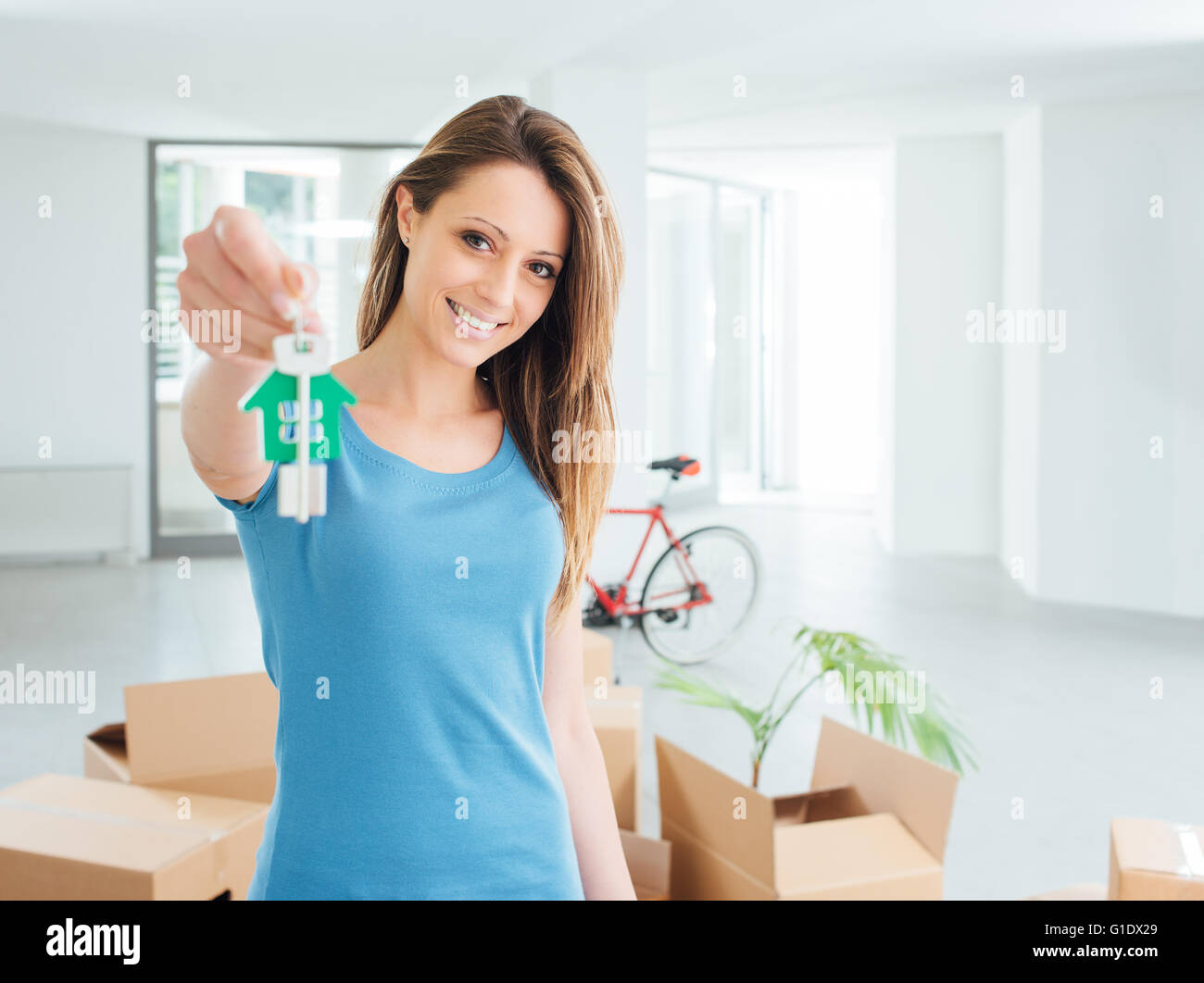 Schönen lächelnden Frau mit Hausschlüssel ihr neues Haus, Immobilien und Relocation-Konzept Stockfoto
