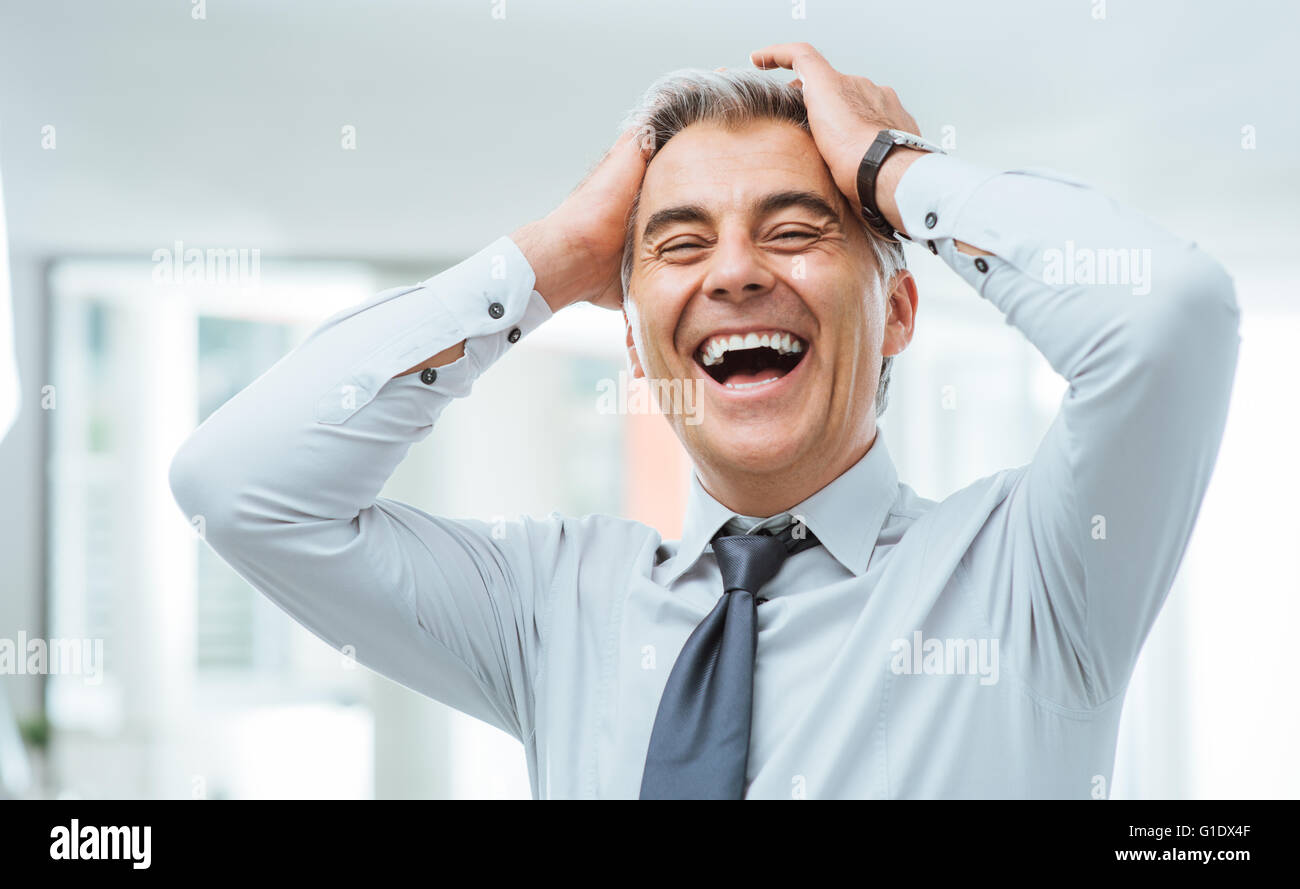 Fröhlichen sorglosen Geschäftsmann Lachen und berührte seine Stirn Stockfoto