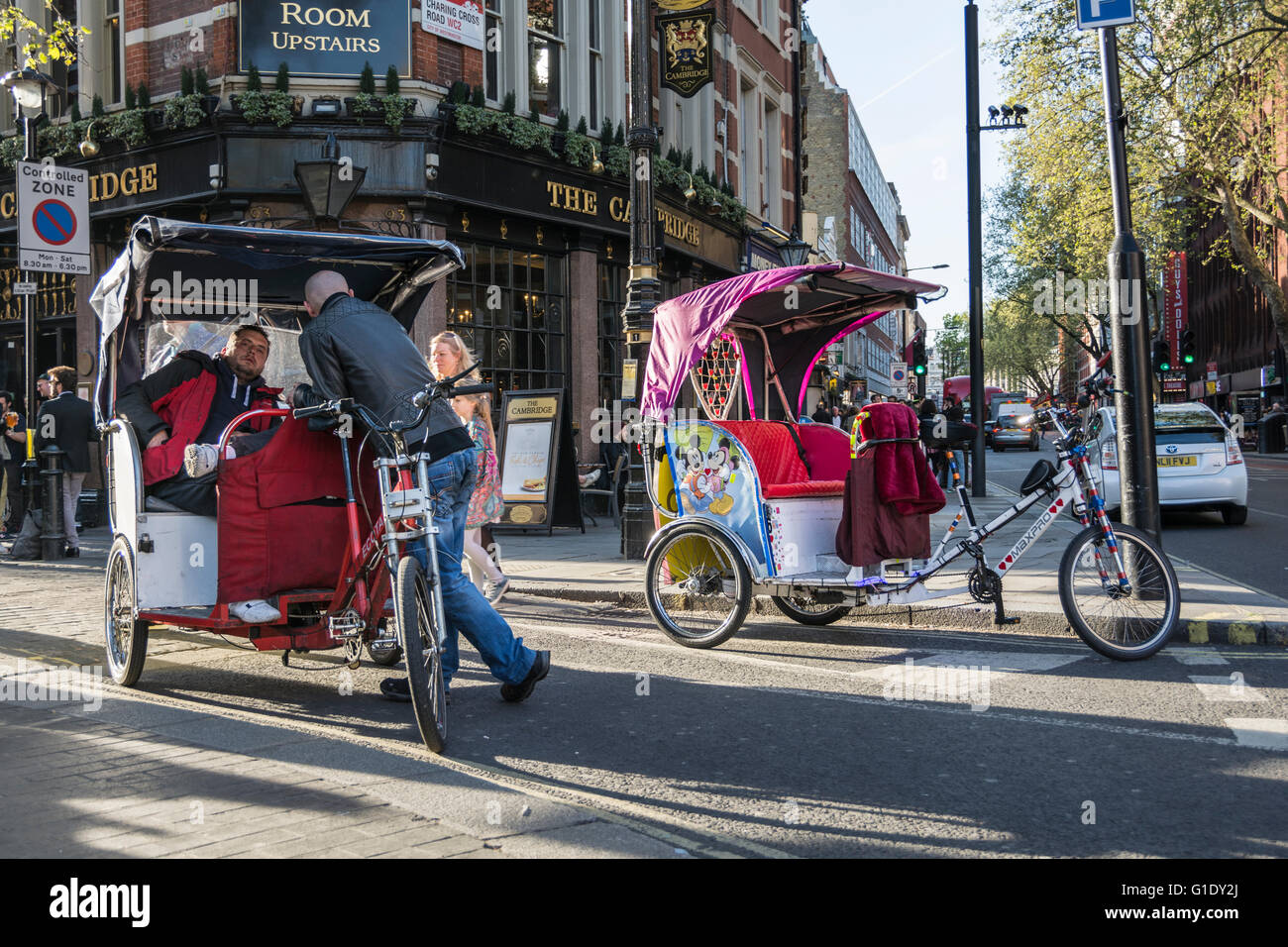 Rikschafahrer machen Sie eine Pause und warten auf Kunden außerhalb der Palast-Theater auf Cambridge Circus in Londons West End, Großbritannien Stockfoto