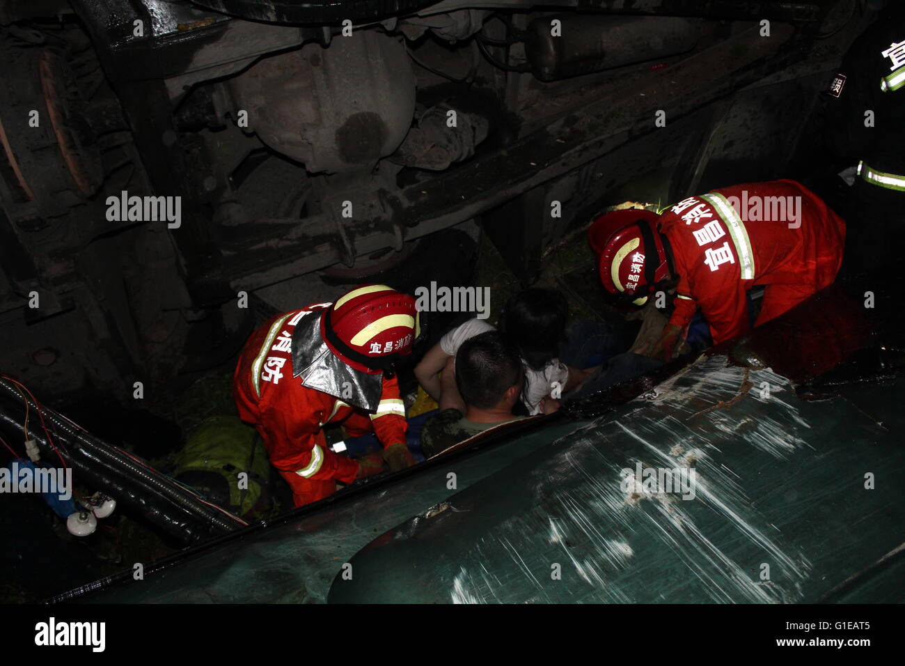 Yichang. 14. Mai 2016. Rettungskräfte helfen eine eingeschlossene Passagiere nach einem Bus drehte eine Autobahn in der Nähe der Stadt Zhijiang, Zentral-China Hubei Provinz, 14. Mai 2016. Eine Person starb und mindestens 24 Menschen wurden verletzt, nachdem ein Bus mit 51 Menschen an Bord von der Autobahn abgekommen und fiel in einen 20-Meter-Straßengraben bei 03:40 am Samstag. © Xinhua/Alamy Live-Nachrichten Stockfoto