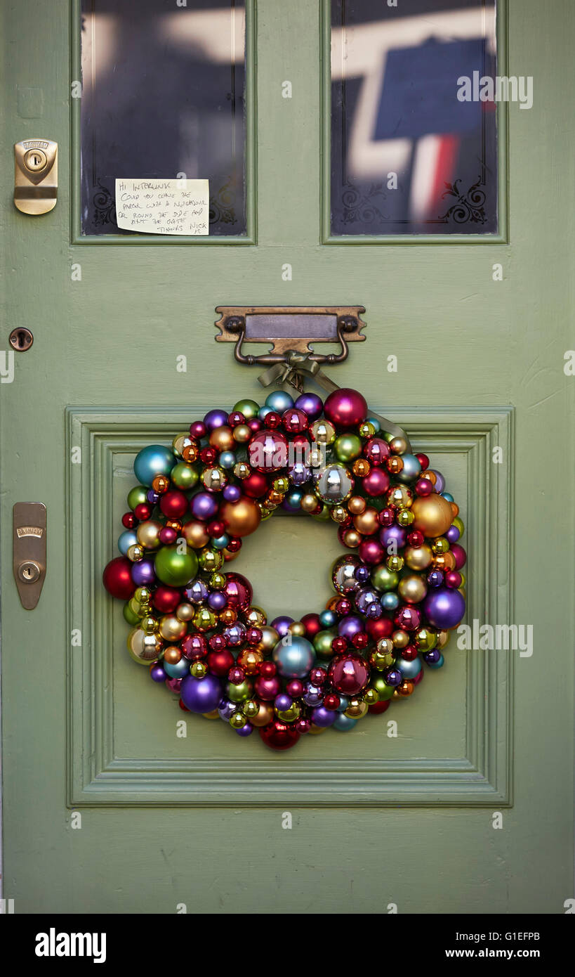 Weihnachtsgirlande an Tür. Girlande aus Kugeln, die an die Tür hängen. Stockfoto