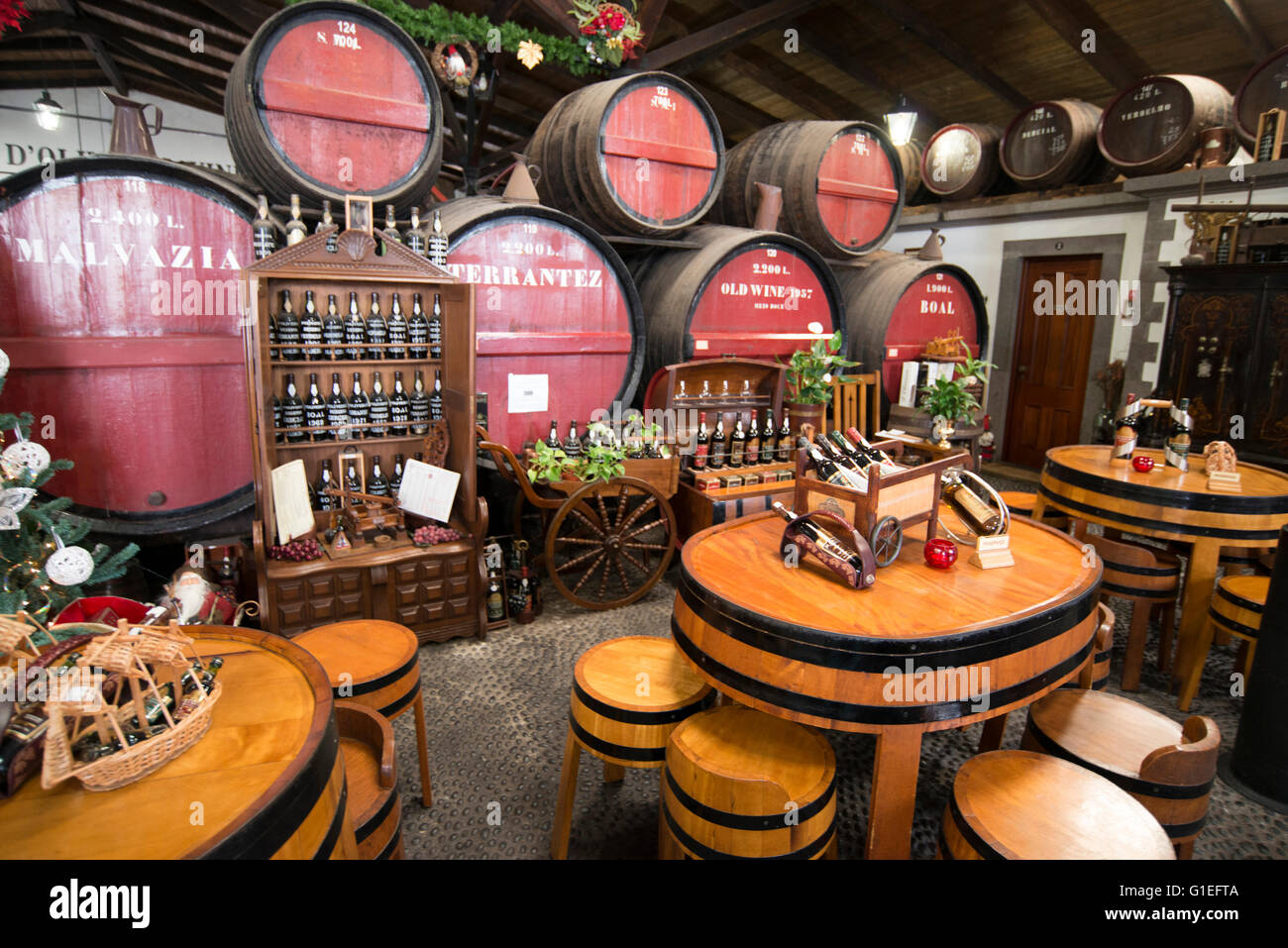 Madeira Weinprobe in Oliveiro Vinhos, Funchal, Madeira, Portugal. Fässer und Flaschen Wein im Blick. Tabellen für Weinproben eingerichtet. Stockfoto