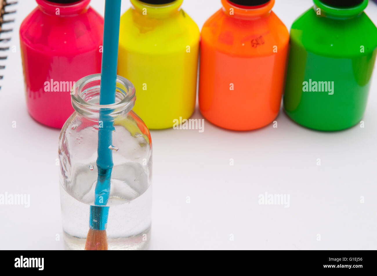 Pinsel in Wasser vor bunten Kinder Farbtöpfe für einen regnerischen Tagesaktivität Stockfoto