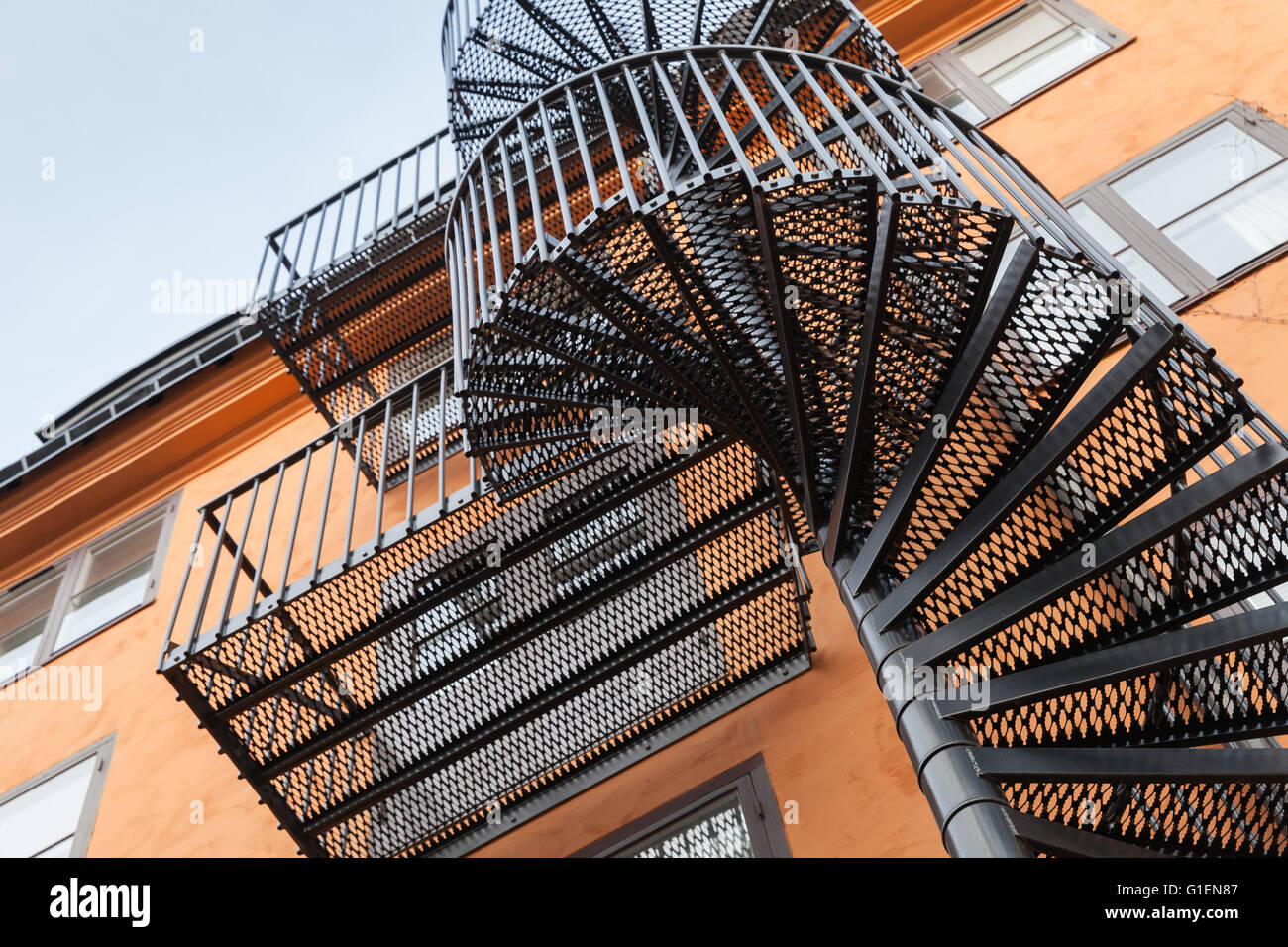 Abstrakt Architektur Fragment, wieder Metallspirale Leiter auf die rote Wand Stockfoto