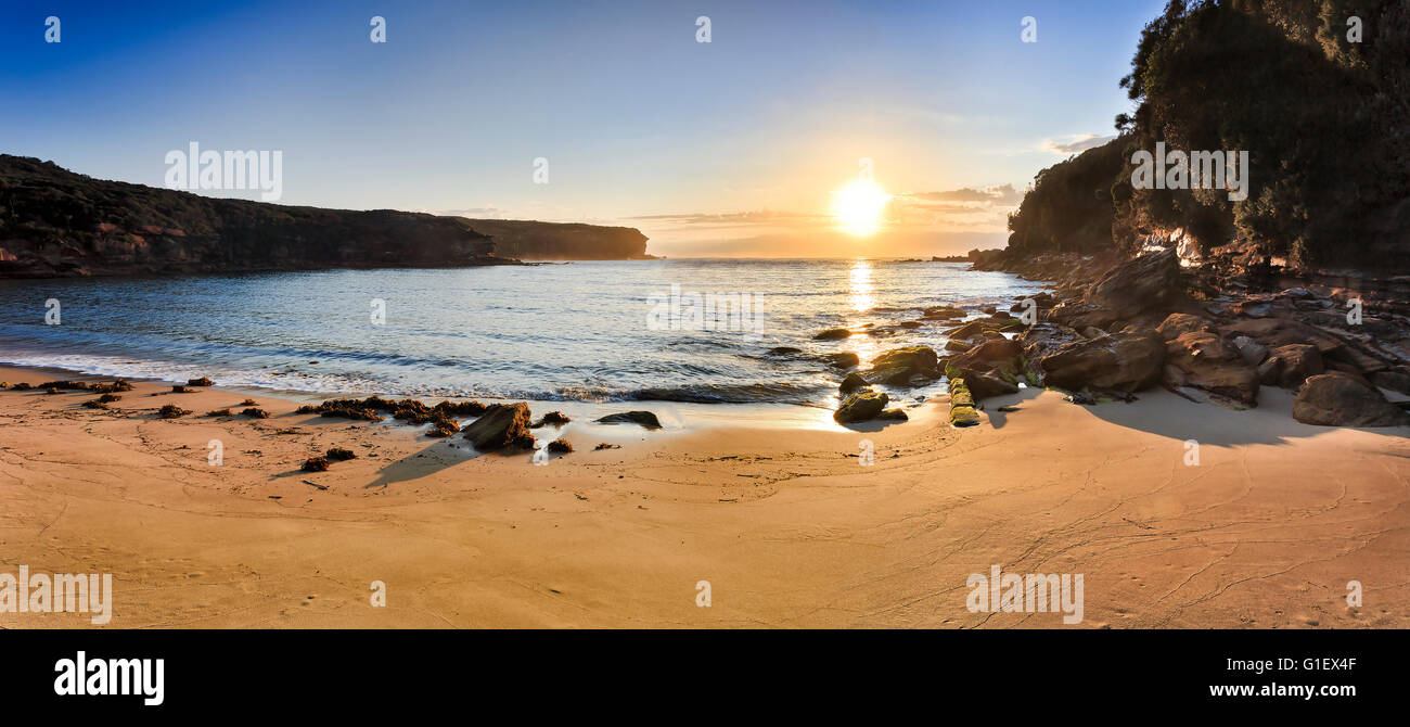 Breite Morgen Panorama des Wattamola sauber Strandsand und Ebbe Felsen im Royal National Park, Australien. Aufgehenden Sonne über Stockfoto