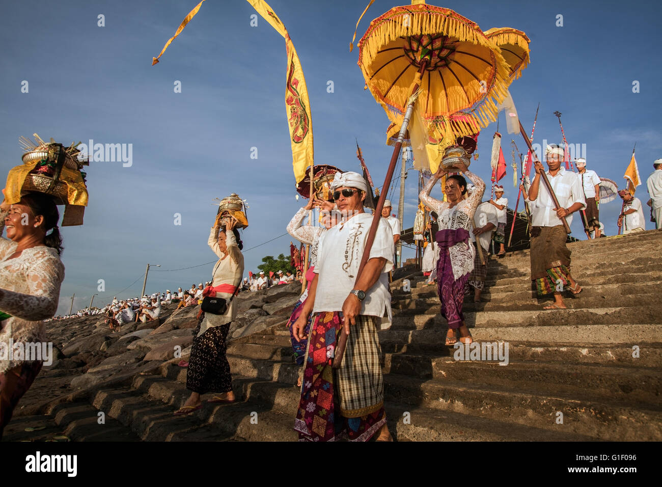 Prozession der balinesischen Hindu mit Fahnen, transparenten und Sonnenschirme an der Melasti Zeremonie während der Balinesen New Year Stockfoto