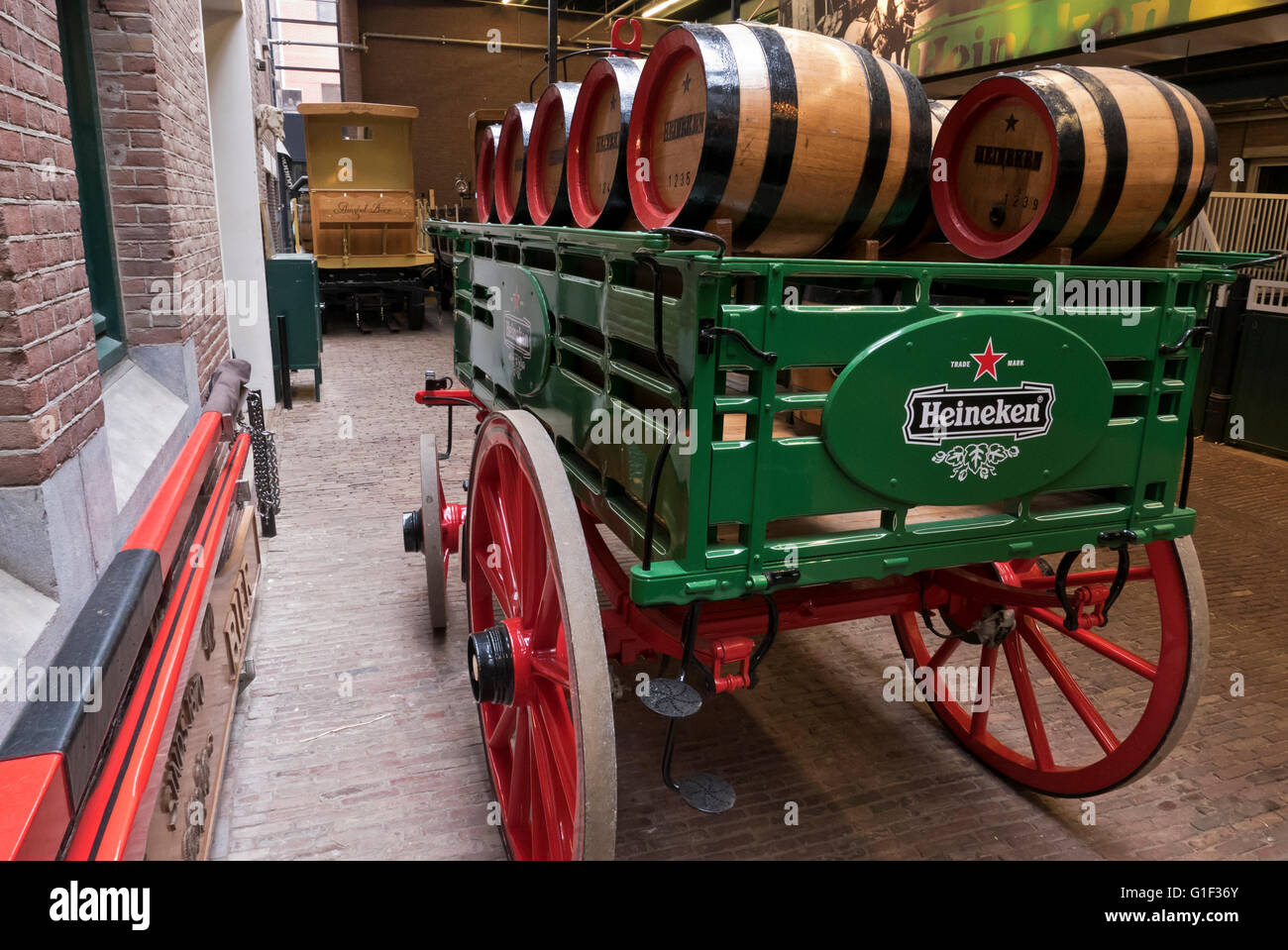 Ein Wagen mit einigen Heineken Fässer befindet sich durch die Ställe in der Heineken-Museum in Amsterdam, Holland, Niederlande. Stockfoto