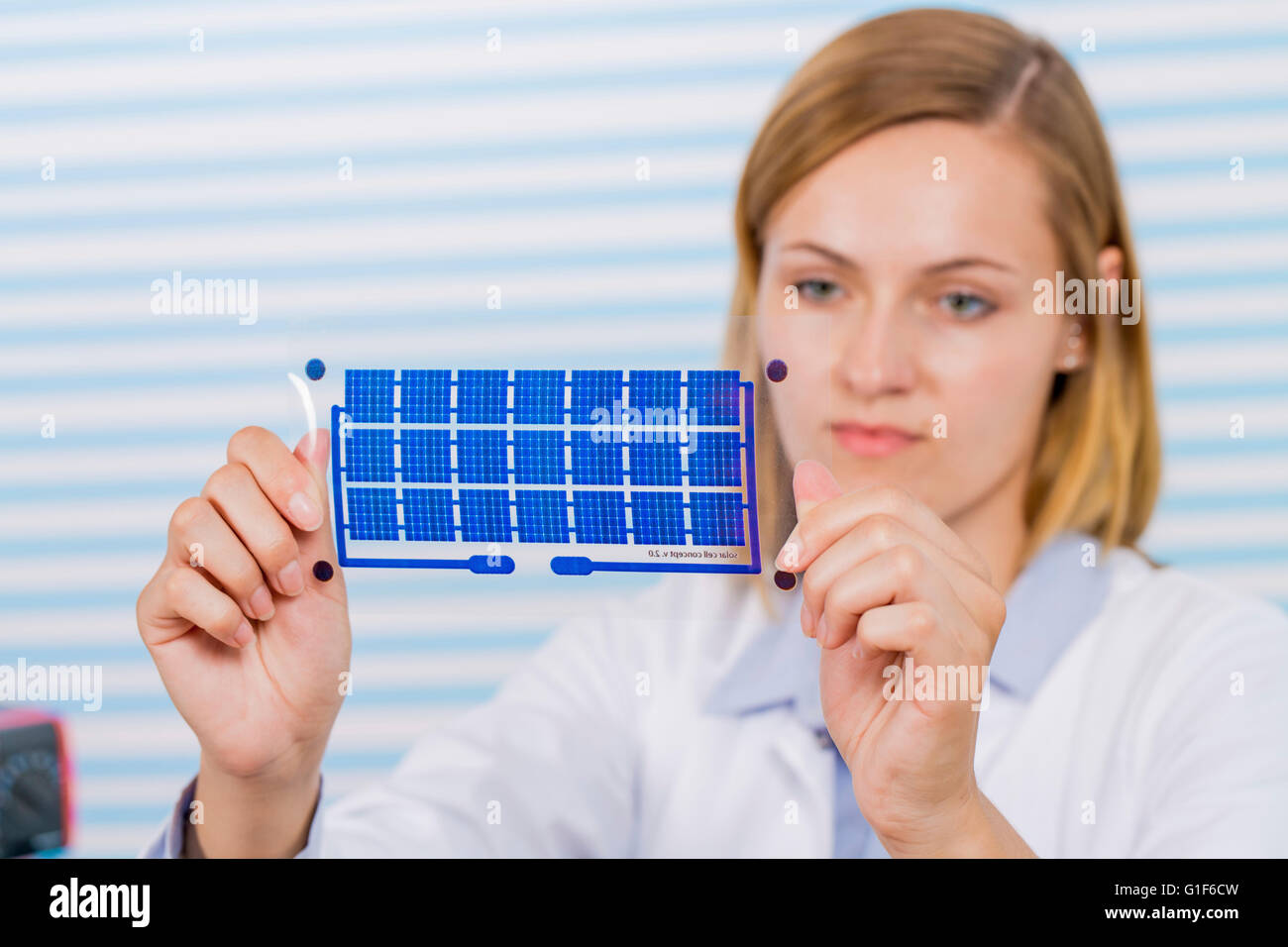 -MODELL VERÖFFENTLICHT. Weiblichen Techniker halten Dünnschicht-Solarzellen. Stockfoto