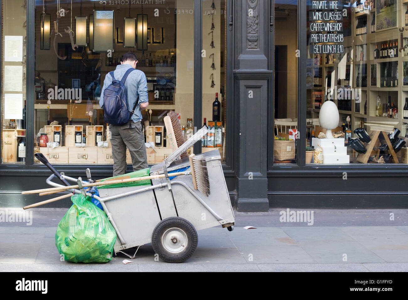 Straße Reinigungswagen vor einem Mann-Window-shopping Stockfoto