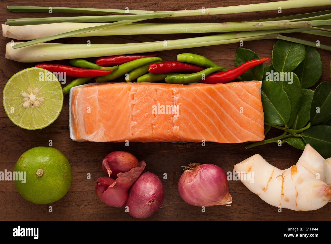 Lachssteak Tom Yam scharfes Essen rustikal Stillleben Zitrone Zitronengras Zwiebel Schalotten Paprika Chili Galgant Kaffernlimette verlässt Stockfoto