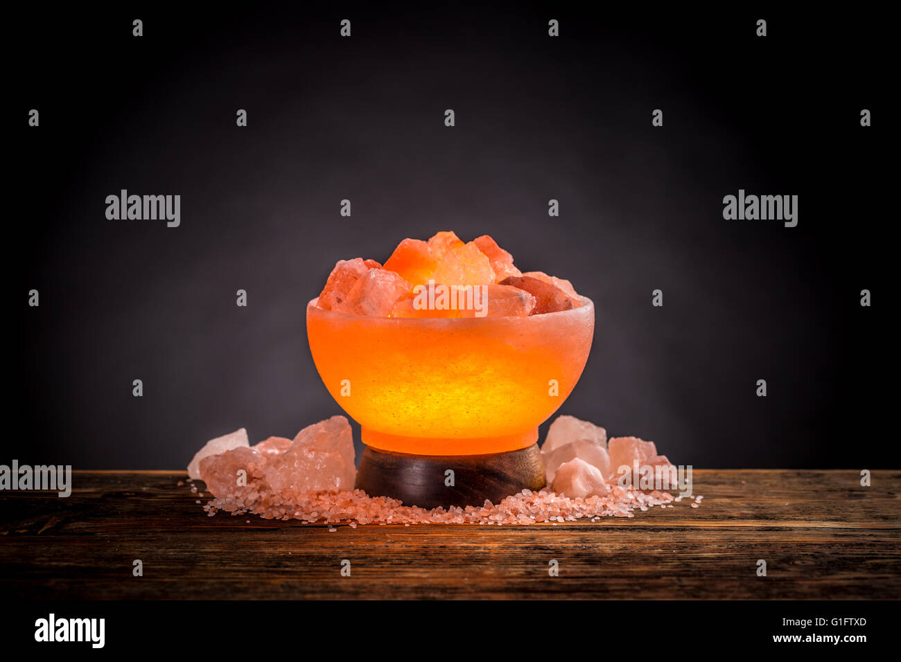 Himalaya rosa Salzlampe auf einem Holztisch eingeschaltet Stockfoto
