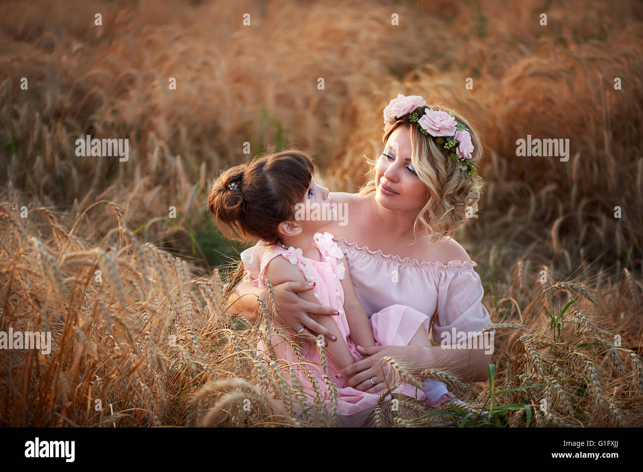 Mutter und Tochter umarmt auf ihrem Kopf einen Kranz von Rosen, weiches Bild Stockfoto