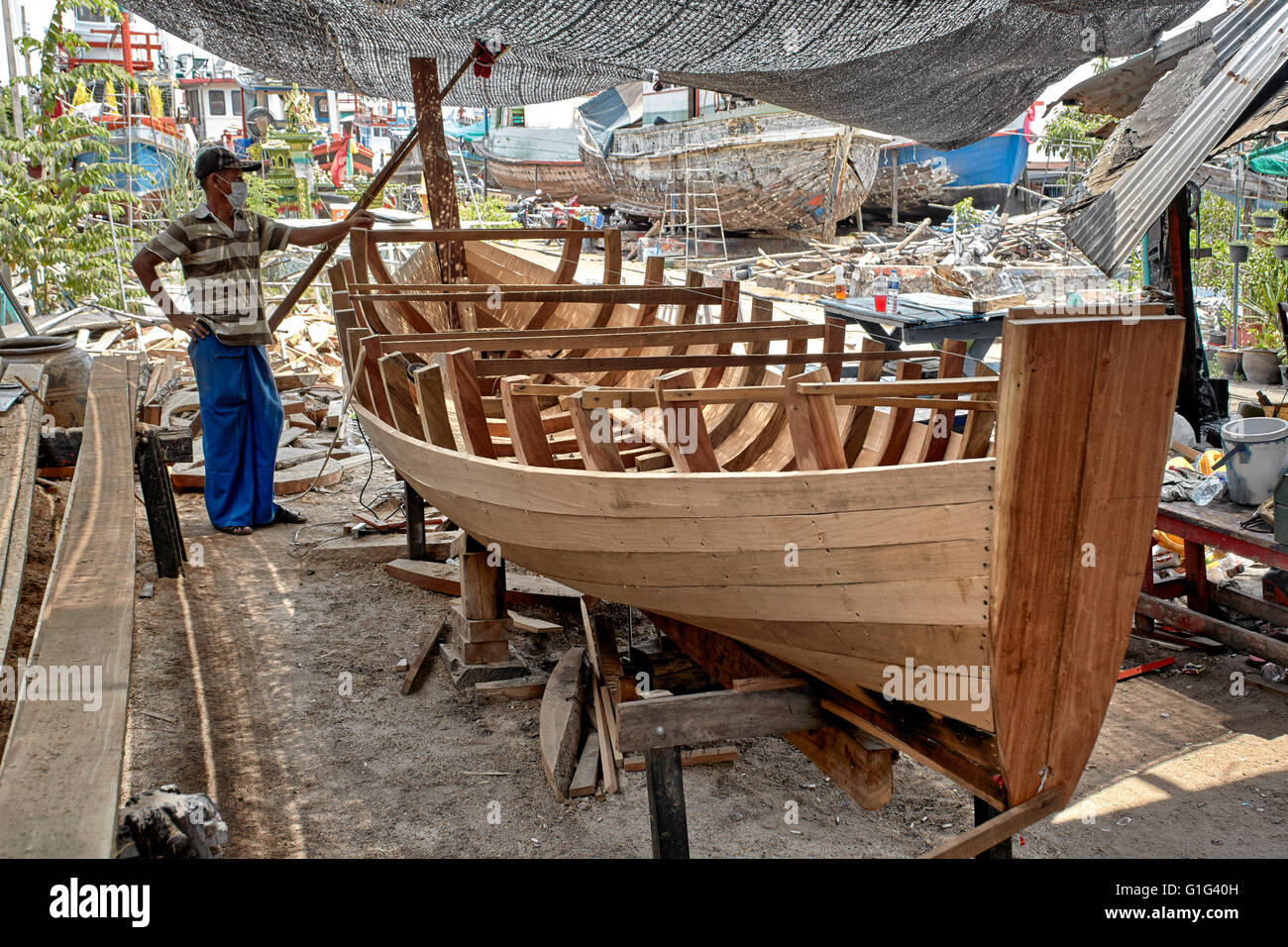 Thailändischer Bootsbauer. Handwerker bauen ein traditionelles Holzboot. Thailand S. E. Asien Stockfoto
