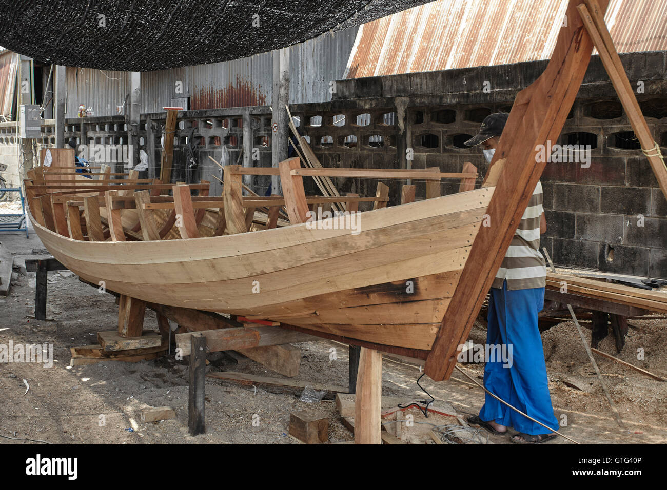 Thailändischer Bootsbauer. Handwerker bauen ein traditionelles Holzboot. Thailand S. E. Asien Stockfoto