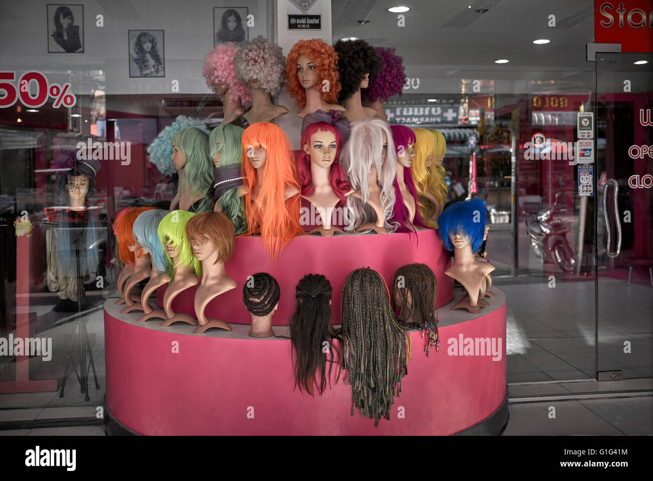 Perücken-Display. Verschiedene farbige Perücken und Haarverlängerung. Stockfoto