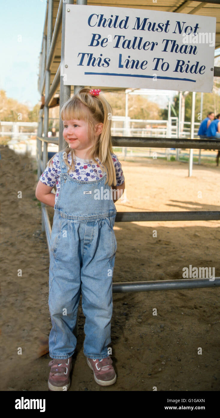 3 Jahre altes Mädchen Überprüfung Zeichen für Höhe Qualifikation Pony reiten © Myrleen Pearson Stockfoto