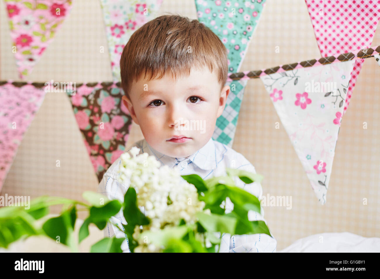 kleiner Junge mit bunten Fahnen auf dem Hintergrund Stockfoto