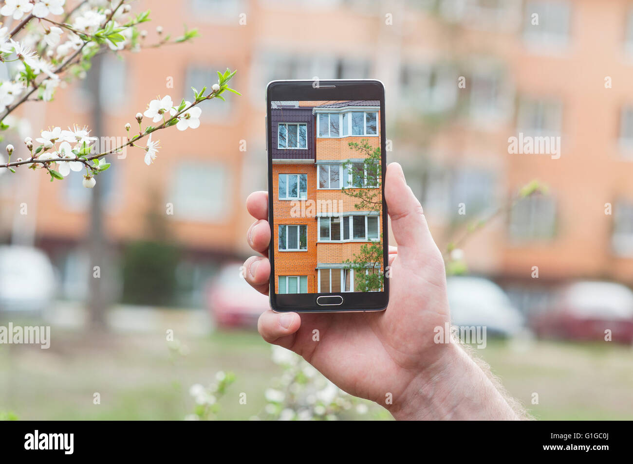 Hand mit Smartphone aufgenommenen Bilder des mehrstöckigen Gebäudes Stockfoto