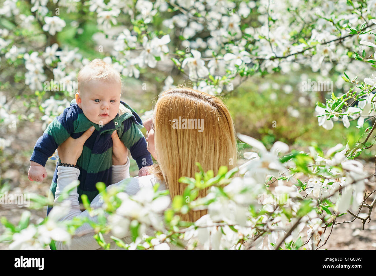 Kleinen Jungen mit jungen Mutter im Frühlingsgarten Blüte Stockfoto