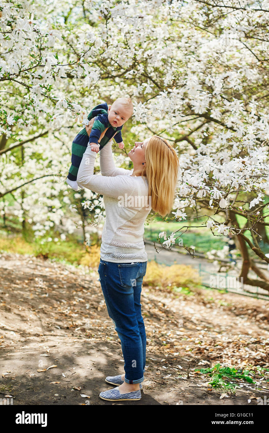 Kleinen Jungen mit jungen Mutter im Frühlingsgarten Blüte Stockfoto