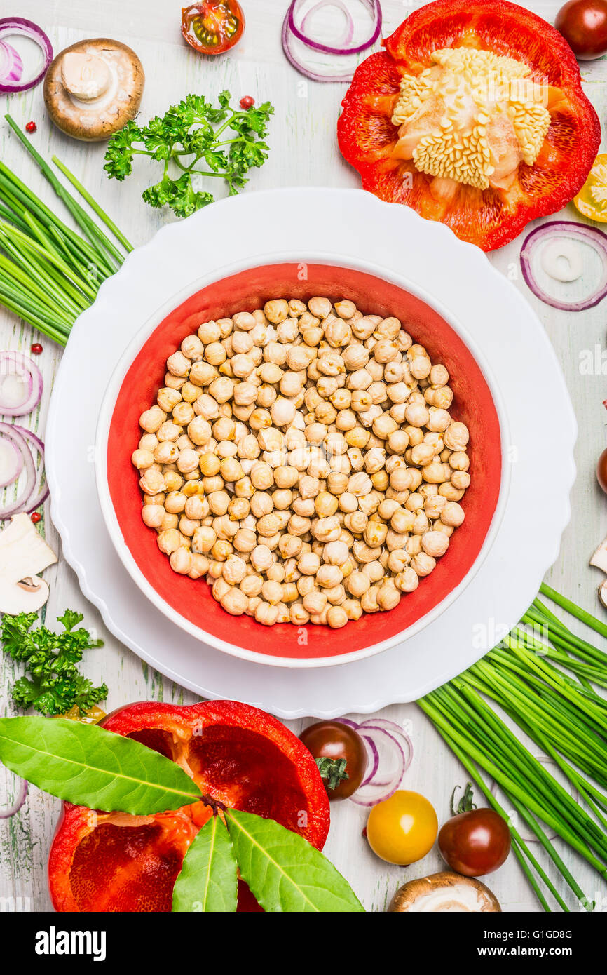 Hummus-Teller und verschiedene Gemüse und Gewürz-Zutaten für leckere vegetarisch Kochen auf rustikalen hölzernen Hintergrund, Stockfoto