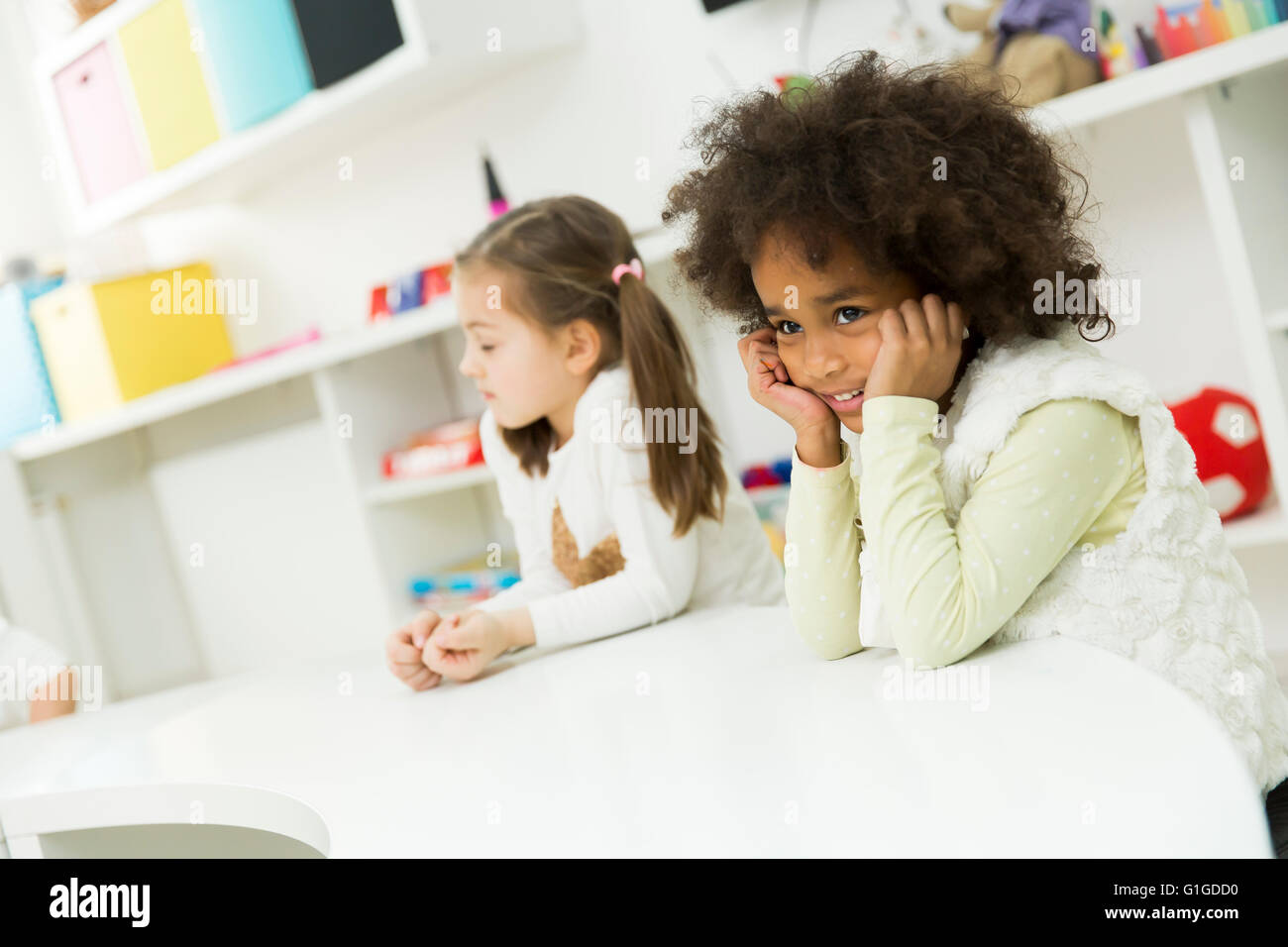 Kinder sitzen am Tisch im kindergarten Stockfoto