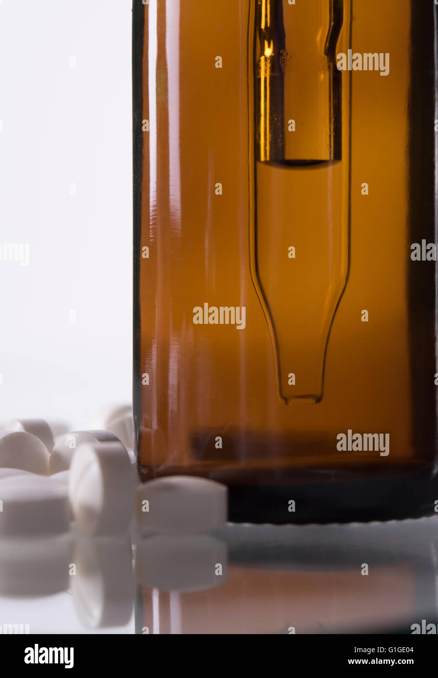 Medizin-Flasche mit Tropfer und weißen Pillen hautnah Stockfoto