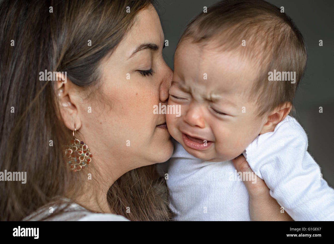 Junge Mutter versucht zu trösten und beruhigen ihr schreiendes Baby Boy. Stockfoto