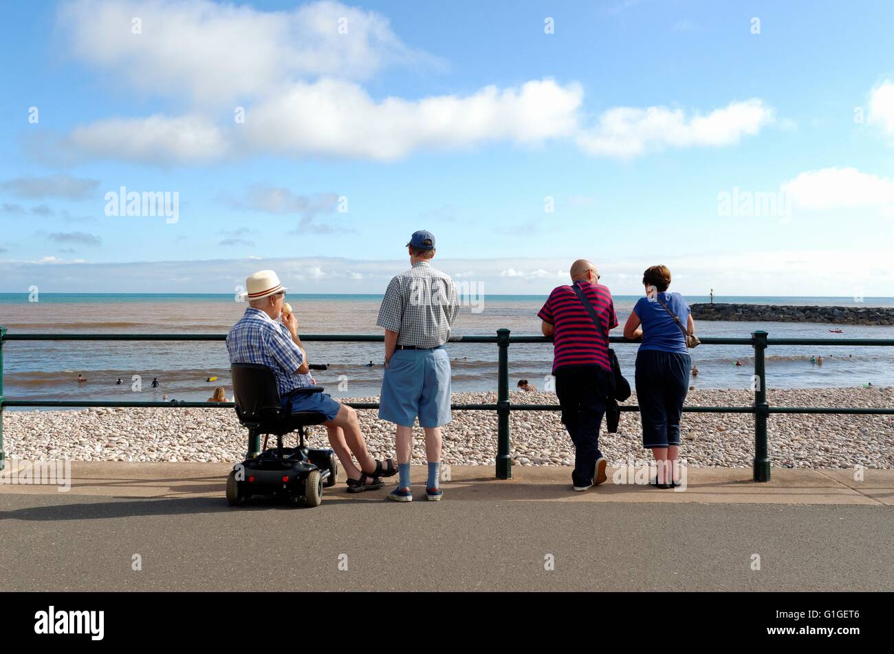 Ältere Menschen, Blick auf das Meer an Sidmouth Küste im Sommer Stockfoto