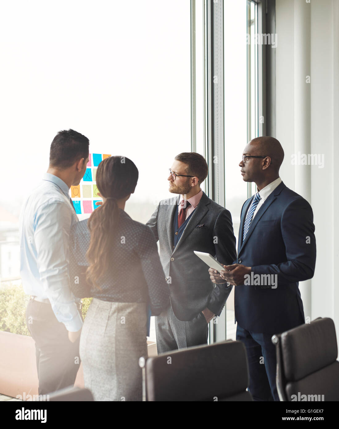 Gemischtrassig Business-Team mit einem Treffen diskutieren ihre Strategie und Ideen für ein neues Projekt, so sie vor einer Bri stehen Stockfoto