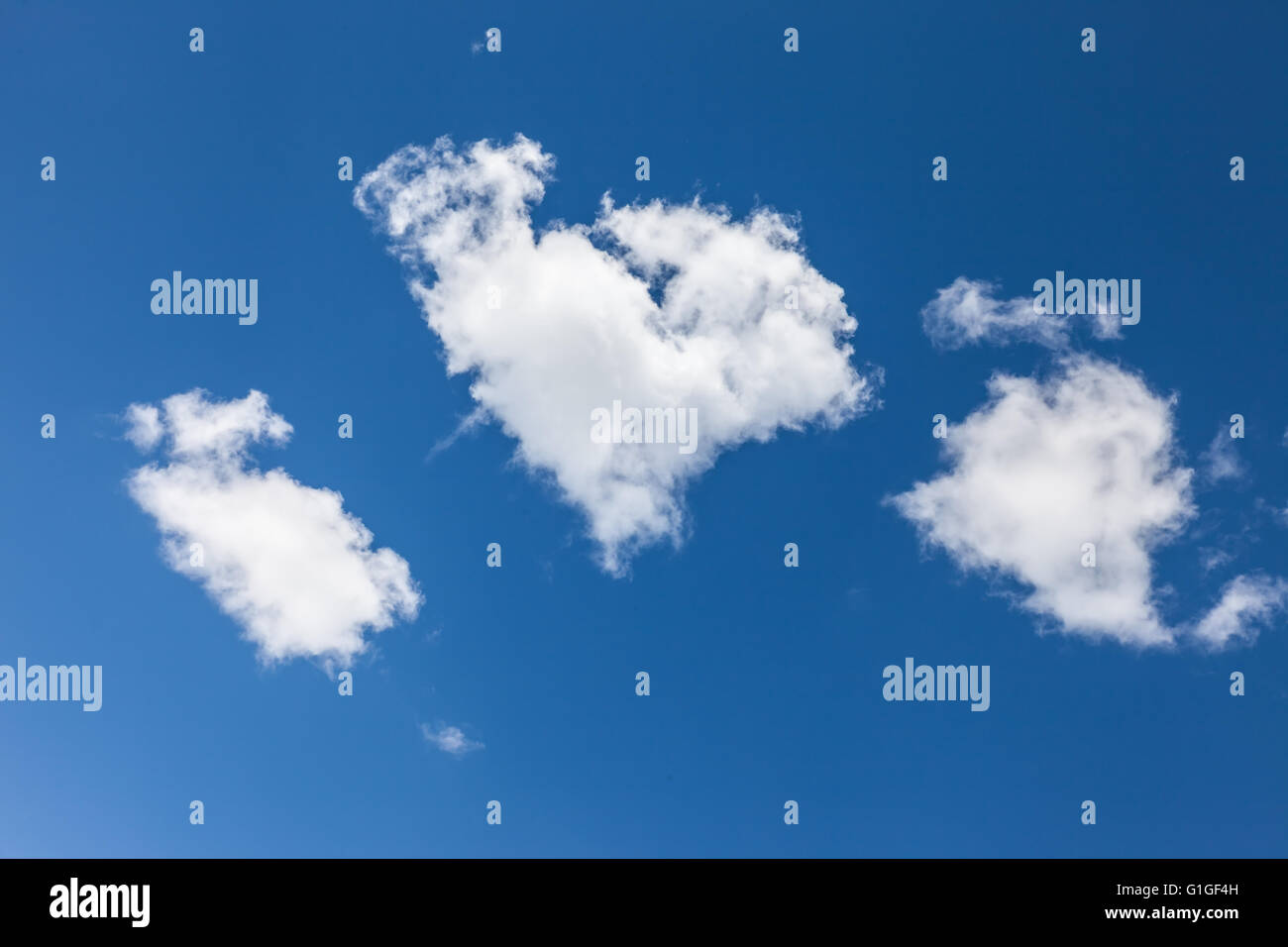 Wolke in Herzform vor blauem Himmel Stockfoto