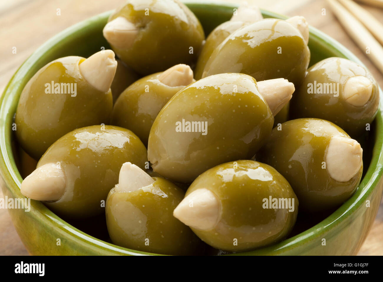 Schüssel mit grünen Oliven, gefüllt mit einer Mandel Stockfoto